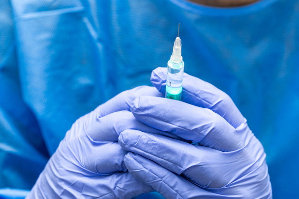 A doctor holding an injection syringe in his hand - Photo, Image