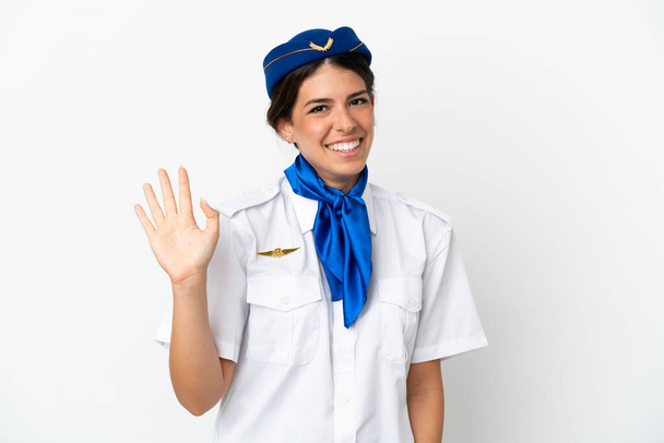 Stewardess kaukasischen Frau isoliert auf weißem Hintergrund salutieren mit der Hand mit glücklichem Gesichtsausdruck - Foto, Bild