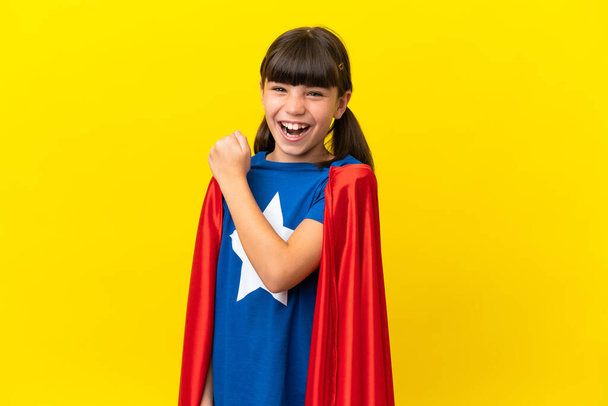 Little super hero kid isolated on purple background celebrating a victory - Foto, Imagen