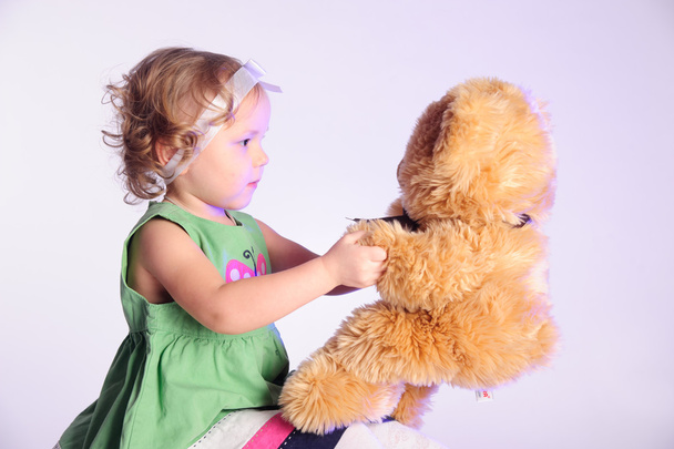 Little girl holding a teddy bear - Фото, зображення