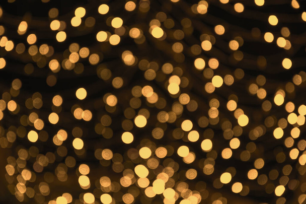 Blurred gold garland. City night light blur bokeh, defocused background. Christmas abstract. - Foto, afbeelding