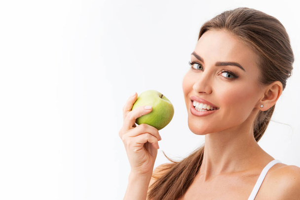 Beautiful woman with perfect skin holding green apple isolated on white background - Фото, зображення