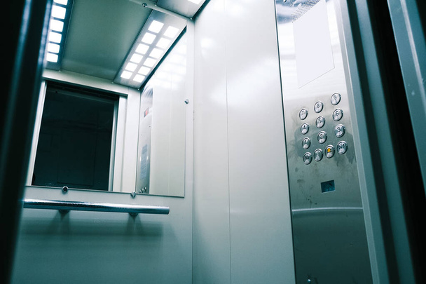 Elevador de metal gris con espejo delante de la puerta. Nuevo ascensor interior - Foto, imagen