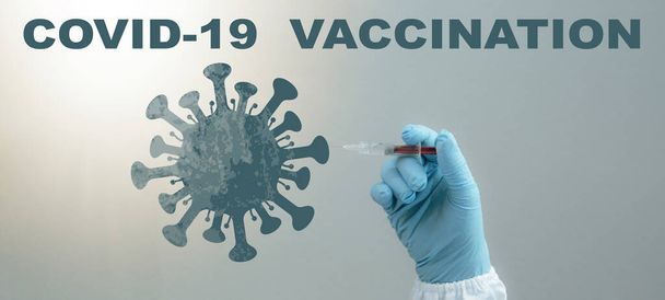 CORONAVIRUS - CORONA VACCINATIE STOP COVID-19 - Arts met spuit in de hand injecteert Corona vaccin in een virus symbool, geïsoleerd op blauwe achtergrond - Foto, afbeelding