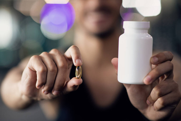 Sports Multivitamins. Athlete Man Holding Blank Jar And Supplement Capsule Pill - Photo, image