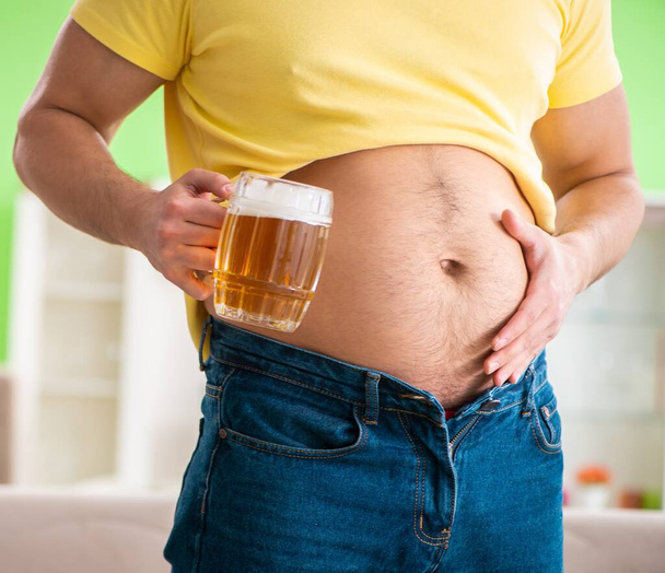 Hombre gordo obeso sosteniendo cerveza en concepto de dieta - Foto, Imagen