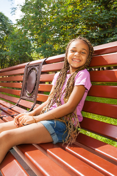 Little black girl sitting on bench - Photo, image