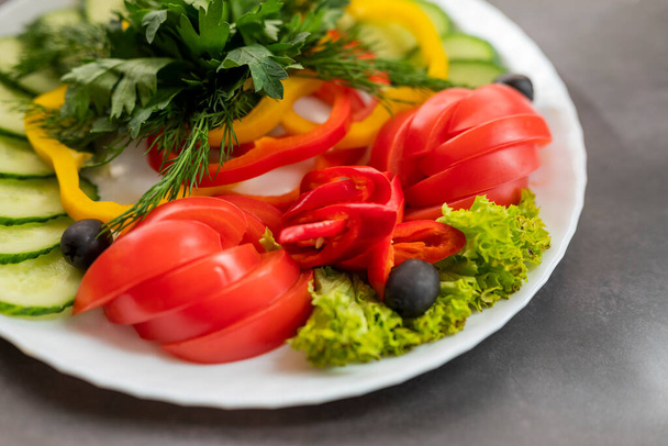 Valikoima tuoreita vihanneksia lautasella. Kurkkujen, paprikan, tomaatin ja basilikan annos persiljalla ja kurkulla. - Valokuva, kuva