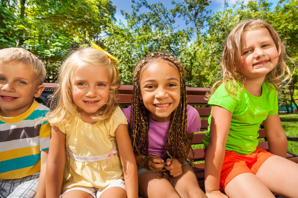 Quatre enfants sur le banc dans le parc
 - Photo, image