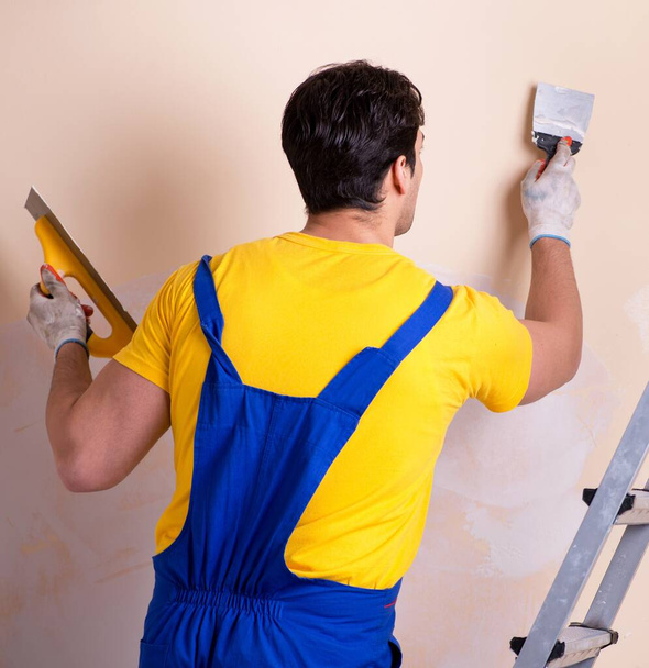 Empregado jovem empreiteiro aplicando gesso na parede - Foto, Imagem