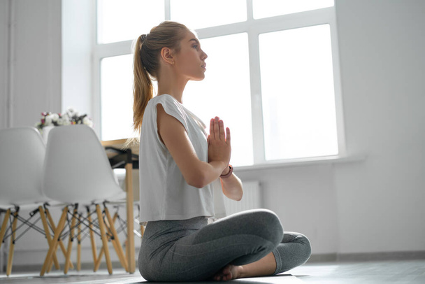Yoga at home, woman do lotus pose. - Foto, afbeelding