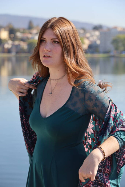 Photo of a Beautiful white girl in a beautiful dress in front of a lake - Photo, image