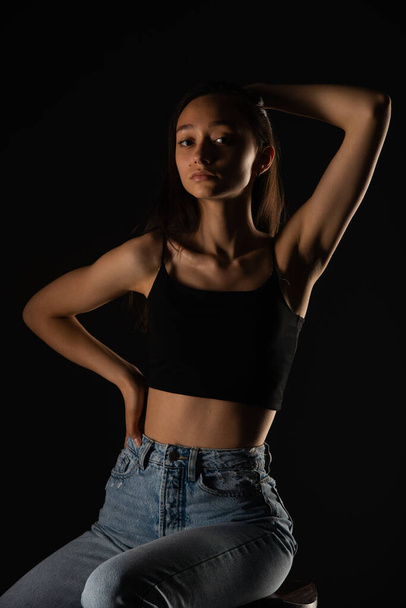 Portrait of attractive young girl looking seductive while posing on black background - Fotó, kép