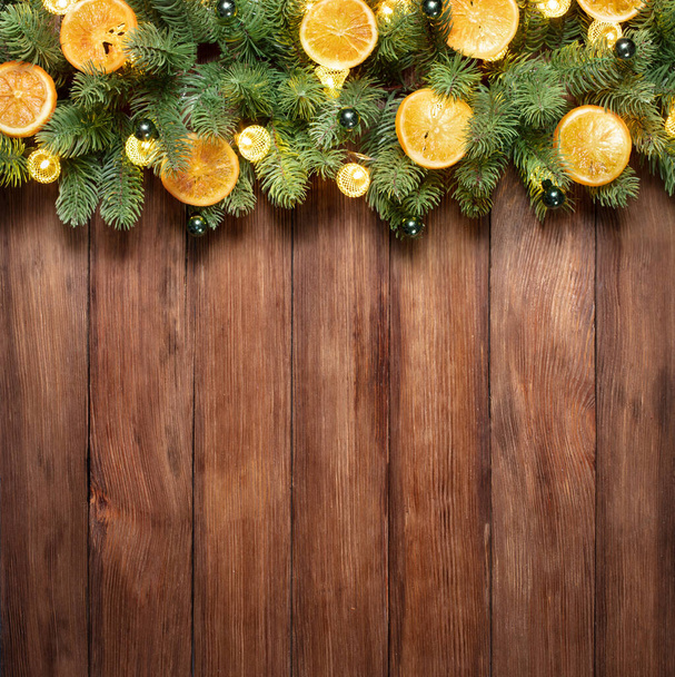 wooden background with copy space decorated of Christmas tree and festive lights - Fotó, kép