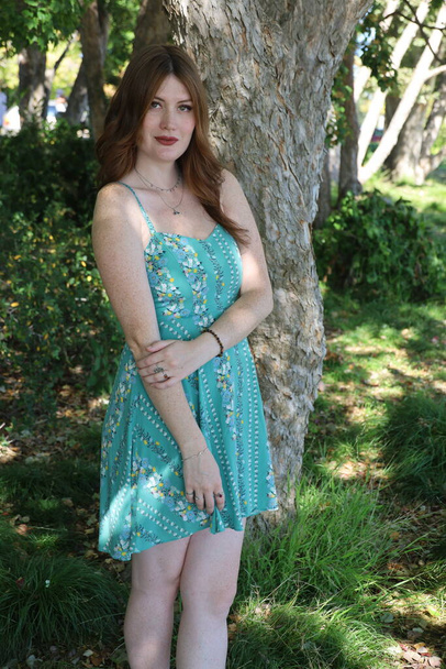 Photo of a Beautiful white girl in a beautiful dress in nature - Fotó, kép