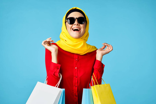 muslim woman in hijab shopping entertainment blue background - 写真・画像
