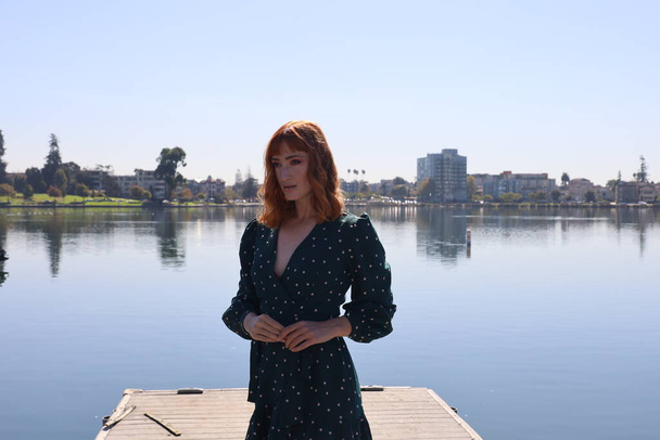 Photo of a Beautiful white girl in a beautiful dress standing in front of a lake - Φωτογραφία, εικόνα