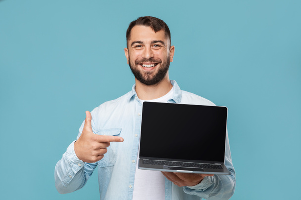 Ευτυχισμένος μεσήλικας καυκάσιος τύπος δείχνει το δάχτυλο στο φορητό υπολογιστή με κενή οθόνη, συνιστά υπολογιστή - Φωτογραφία, εικόνα