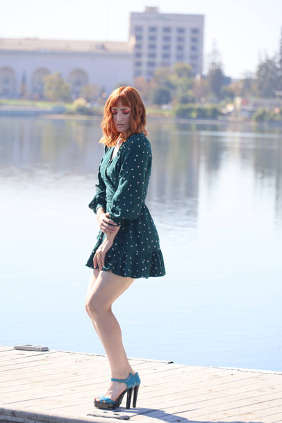 Photo of a Beautiful white girl in a beautiful dress standing in front of a lake - Valokuva, kuva