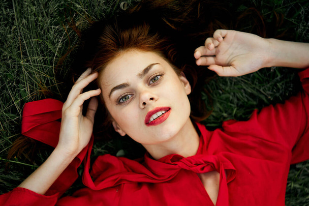 woman in red dress lies on the grass address fashion summer - Fotoğraf, Görsel