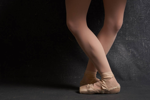 crossed legs ballerinas ballet shoes performance dark background - Фото, изображение