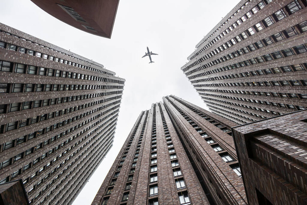 towers skyscrapers and a airplane jet grey foggy weather gray colors,geometric leading lines .concept business corporate aviation  - 写真・画像