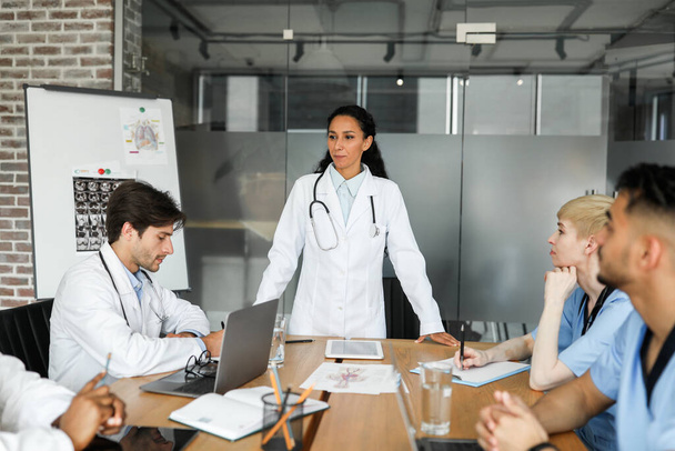 Brunette woman chief physician making presentation in front of colleagues - Photo, Image