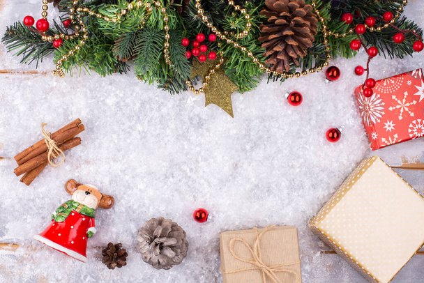 Χριστουγεννιάτικο εορταστικό φόντο με ένα ελάφι παιχνίδι ντυμένο ως Άγιος Βασίλης, χριστουγεννιάτικο δέντρο διακοσμημένο με διακόσμηση, κουτιά με padarkas στο χιόνι, εορταστικό φόντο, κοντινό πλάνο, επίπεδο lay, αντίγραφο χώρου - Φωτογραφία, εικόνα