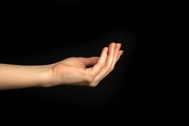 Young lady hand gesture on a black background isolated - 写真・画像