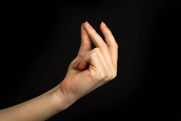 Χέρι χειρονομία θραύση δάχτυλα, εύκολο σημάδι και το σύμβολο σε μια μαύρη φωτογραφία φόντου - Φωτογραφία, εικόνα