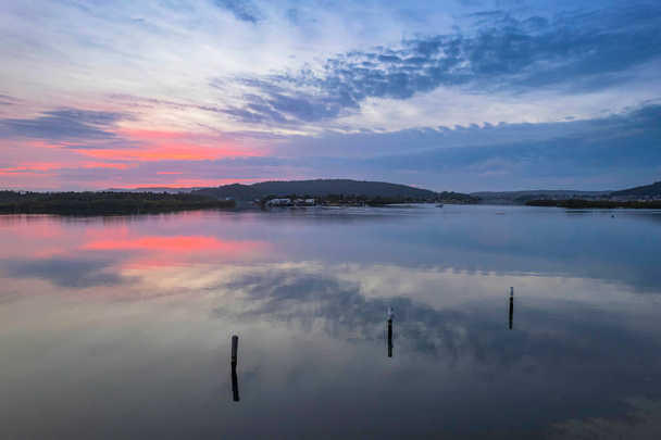 Sunrise, clouds and reflections at Woy Woy Waterfront on the Central Coast, NSW, Australia. - 写真・画像