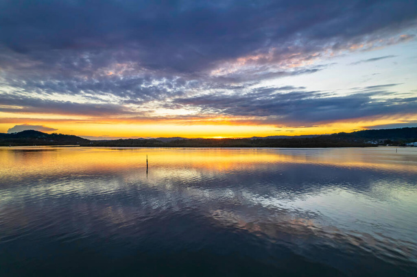 Sunrise, cloud and reflections at Woy Woy Waterfront on the Central Coast, NSW, Australia. - 写真・画像