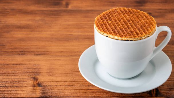 Geleneksel Hollanda usulü otantik Hollanda tatlı ev yapımı lezzetli kahverengi waffle erimiş tuzlu karamelli bal pekmezi ve Stroopwafel adında sıcak kahve sütlü çay. - Fotoğraf, Görsel