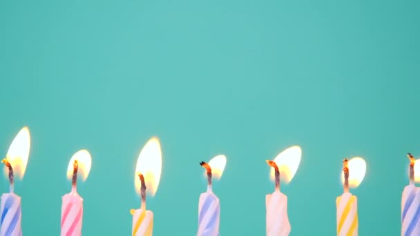 Happy Birthday concept Gemaakt van Brandende Kleurrijke Kaarsen op blauwe of turquoise achtergrond. Zeven jaar verjaardagskaarsen branden. Full HD-video in slow motion - Video