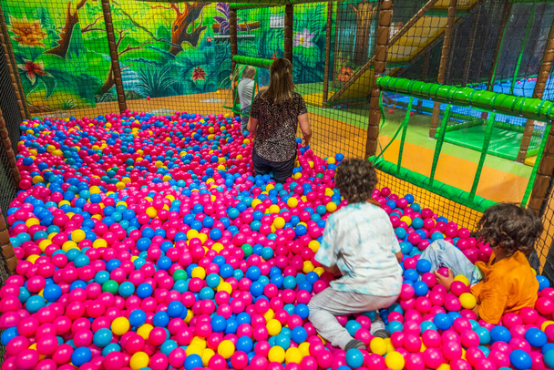 Lapsi ja aikuinen nainen hauskaa sisätiloissa pallo allas lasten aktiviteettikeskus. Ruotsi.  - Valokuva, kuva