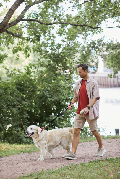 Man Walking Dog in Park Side View - Foto, immagini
