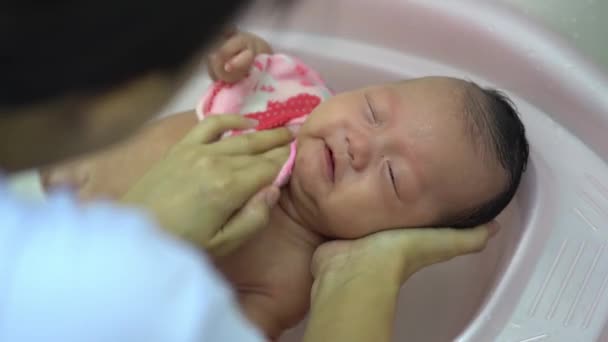 Madre pulire il viso e il corpo del bambino in bagno - Filmati, video