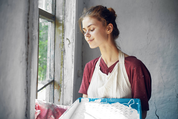 woman in apron painter repair painting window - Foto, Imagem