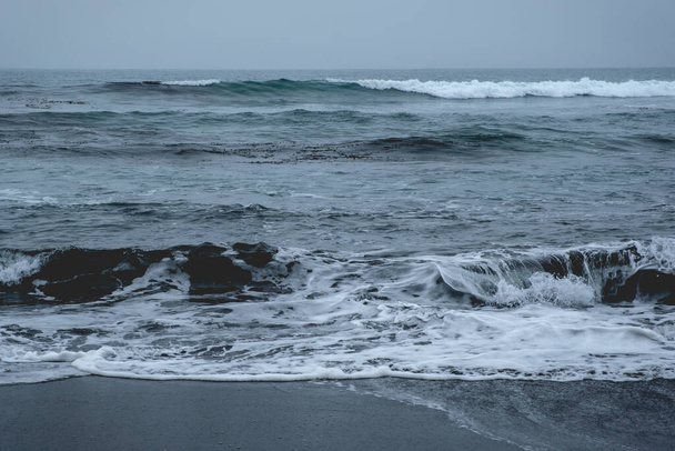Panoramic view of the pacific ocean with waves, the horizon with cloudy sky and the shore and beach - Foto, afbeelding