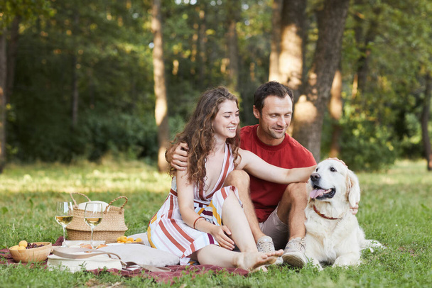 Couple Enjoying Picnic Outdoors with Dog - Foto, Bild