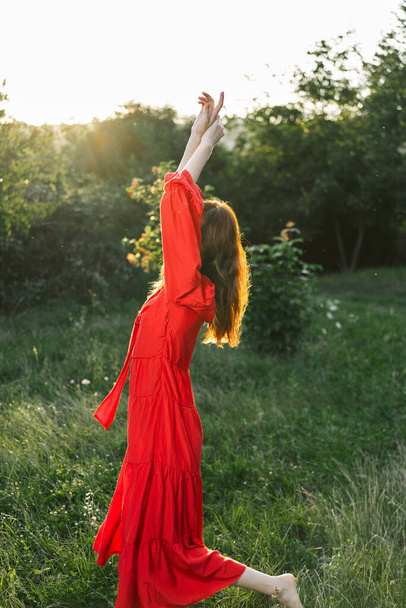 attractive woman in red dress outdoors in freedom field - Фото, изображение