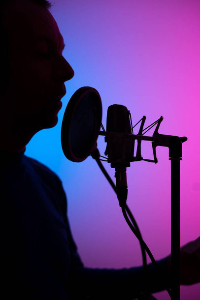 Voiceover artista dublador em estúdio de gravação vocal com microfone diafragma larg e escudo antipop. - Foto, Imagem