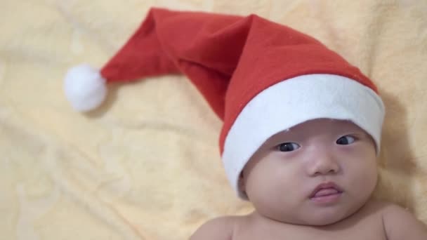 Kleines Baby mit Weihnachtskopf blickt in Kamera - Filmmaterial, Video
