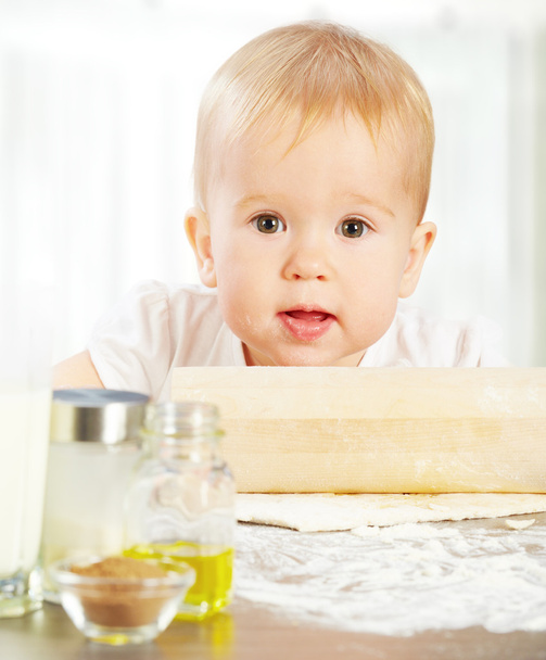 Little baby girl is cooking, kneads dough baking - Foto, immagini