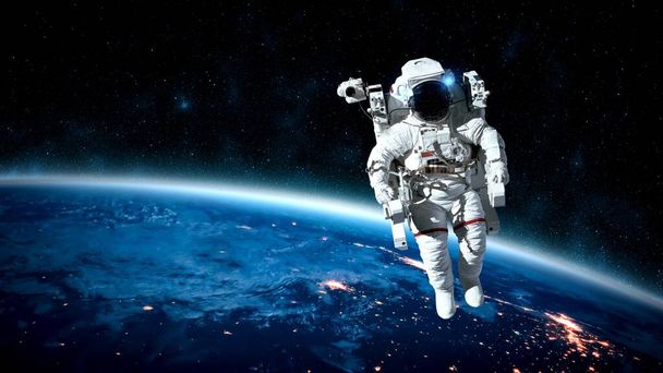 宇宙飛行士は宇宙飛行士の仕事をしながら宇宙遊泳を行います - 写真・画像