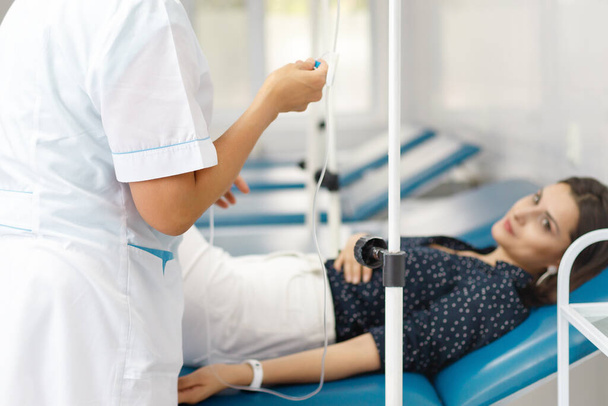 Медсестра з Центральної Азії готова доставляти солону капсулу пацієнту на диван.. - Фото, зображення