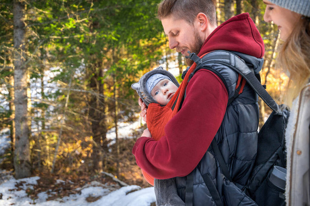 Passeggiata invernale all'aperto di una giovane famiglia con il loro neonato, spazio copia. - Foto, immagini