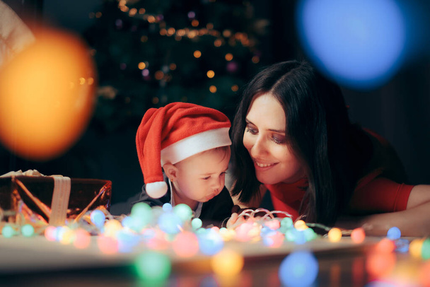 Mother and Baby Celebrating Christmas under the Tree - Фото, изображение