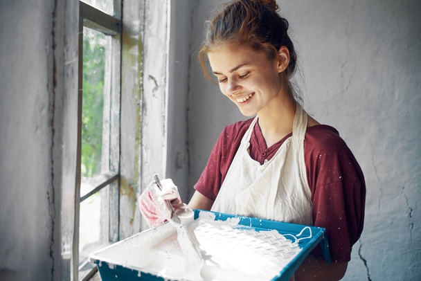 Önlüklü kadın boyacı, boyama penceresi. - Fotoğraf, Görsel