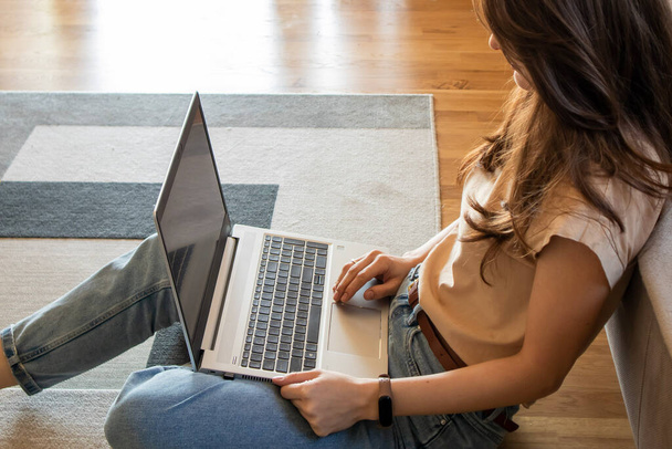 Закрыть женщину, работающую из дома, ноутбуком на диване - Фото, изображение